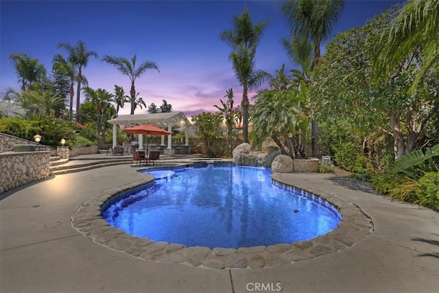 10847 Leota Ln, Riverside, CA 92503 - pool at dusk featuring a patio area and an outdoor pool