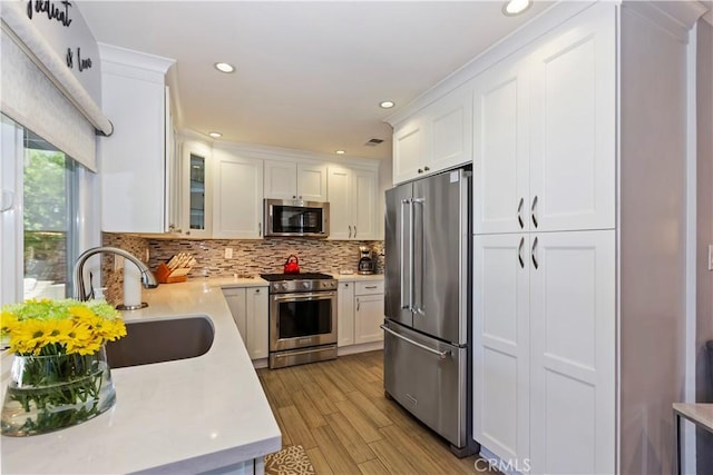 1335 N Vallejo Way, Upland, CA 91786 - kitchen featuring high quality appliances, light countertops, white cabinets, backsplash, and light wood finished floors