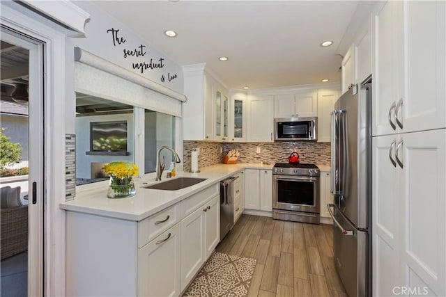 1335 N Vallejo Way, Upland, CA 91786 - kitchen featuring appliances with stainless steel finishes, white cabinets, decorative backsplash, light countertops, and glass insert cabinets