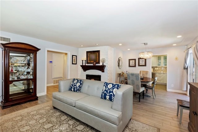 1335 N Vallejo Way, Upland, CA 91786 - living room with light wood-type flooring, a chandelier, a fireplace, and recessed lighting