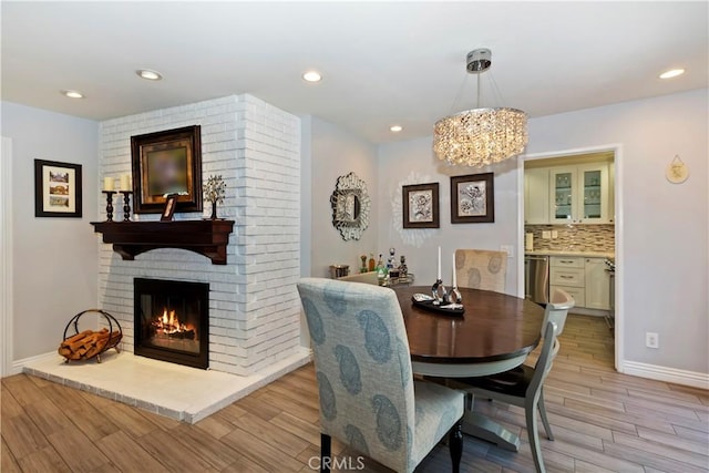 1335 N Vallejo Way, Upland, CA 91786 - dining space with light wood-style flooring, a fireplace, a chandelier, and recessed lighting