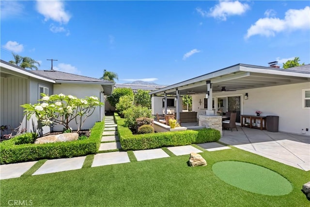 1335 N Vallejo Way, Upland, CA 91786 - rear view of property featuring a patio, outdoor lounge area, a lawn, stucco siding, and a putting area