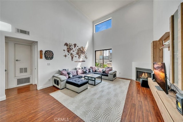 625 S Berendo St Unit 604, Los Angeles, CA 90005 - living room with high vaulted ceiling, a warm lit fireplace, healthy amount of natural light, wood finished floors, and ornamental molding