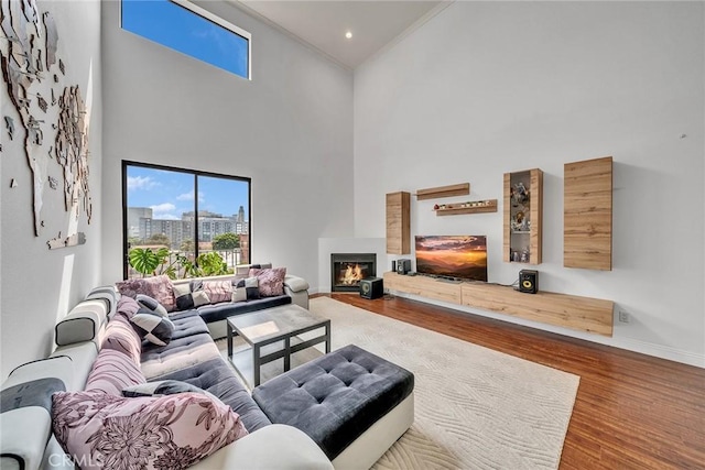 625 S Berendo St Unit 604, Los Angeles, CA 90005 - living room with a towering ceiling, wood finished floors, a glass covered fireplace, and crown molding