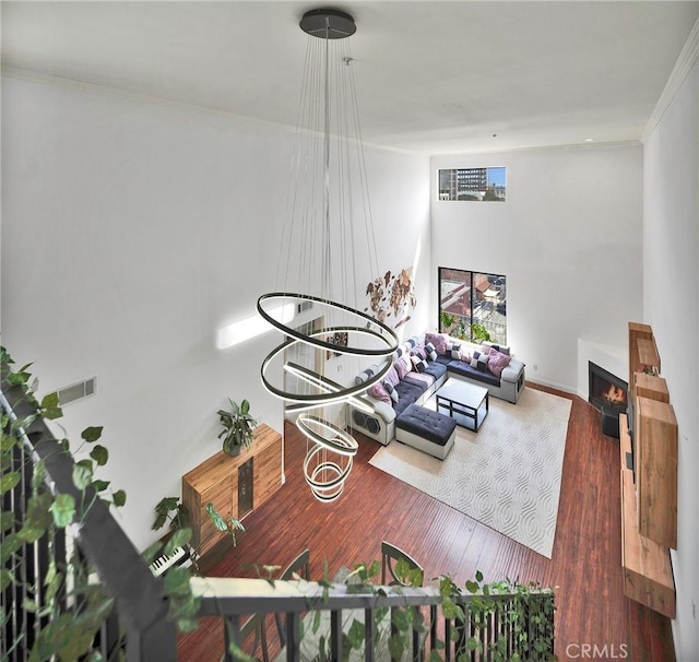 625 S Berendo St Unit 604, Los Angeles, CA 90005 - living area featuring a lit fireplace, wood finished floors, and ornamental molding