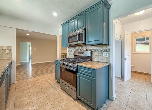6706 Melvin Ave, Reseda, CA 91335 - kitchen featuring appliances with stainless steel finishes, light tile patterned floors, tasteful backsplash, recessed lighting, and blue cabinets