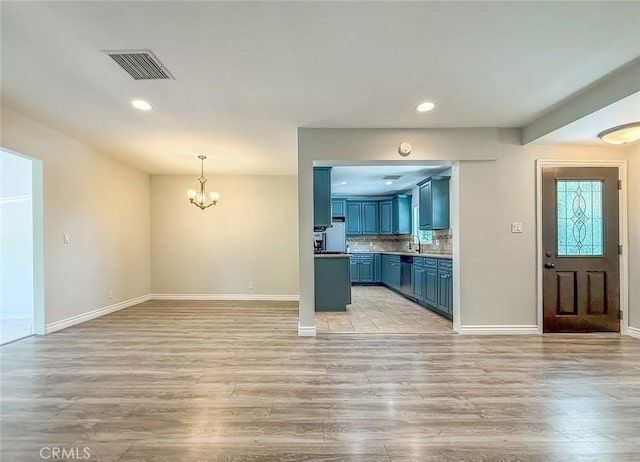 6706 Melvin Ave, Reseda, CA 91335 - kitchen with blue cabinetry, a chandelier, light wood-style flooring, recessed lighting, and decorative backsplash