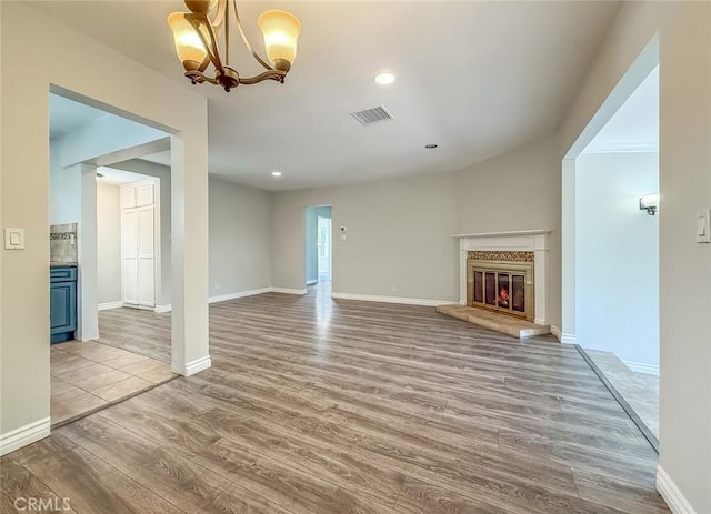 6706 Melvin Ave, Reseda, CA 91335 - unfurnished living room with wood finished floors, a glass covered fireplace, a chandelier, and recessed lighting