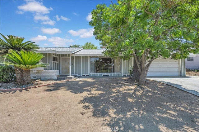 20468 College Blvd, Riverside, CA 92507 - view of front of home with board and batten siding, driveway, and an attached garage