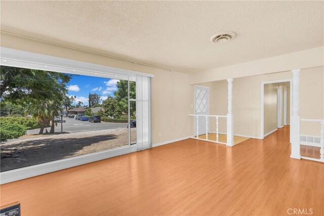 20468 College Blvd, Riverside, CA 92507 - spare room featuring a textured ceiling, wood finished floors, and ornate columns
