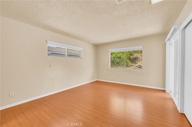 20468 College Blvd, Riverside, CA 92507 - empty room with light wood-style flooring and a textured ceiling