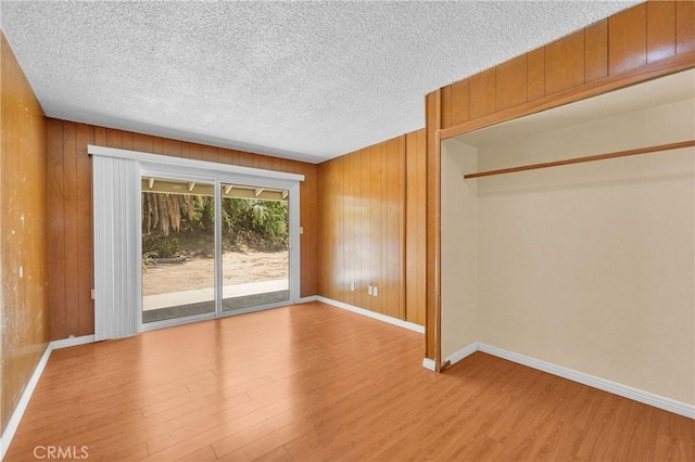 20468 College Blvd, Riverside, CA 92507 - unfurnished bedroom featuring access to exterior, wood finished floors, a textured ceiling, and wooden walls