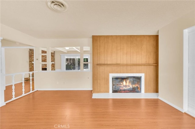 20468 College Blvd, Riverside, CA 92507 - unfurnished living room with wood finished floors, a lit fireplace, and a textured ceiling