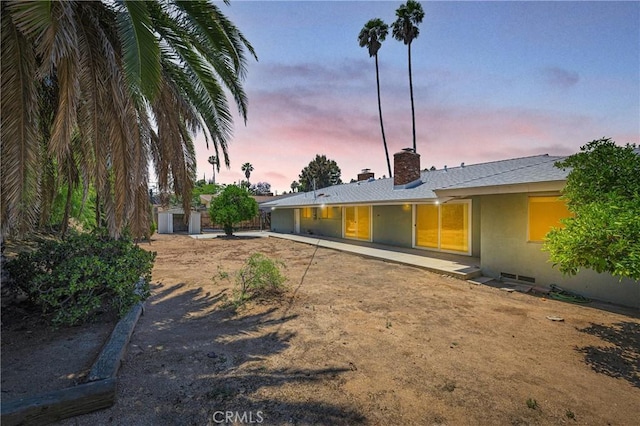 20468 College Blvd, Riverside, CA 92507 - back of property at dusk featuring a chimney and a patio