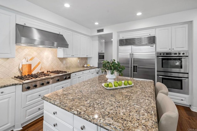 3474 Camino Cereza, Carlsbad, CA 92009 - kitchen with built in appliances, range hood, light stone countertops, dark wood-style floors, and recessed lighting