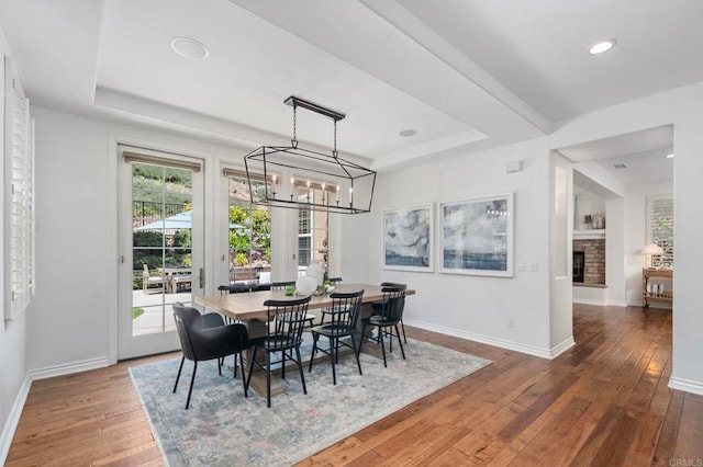 3474 Camino Cereza, Carlsbad, CA 92009 - dining room with a tray ceiling, wood-type flooring, a chandelier, a fireplace, and recessed lighting