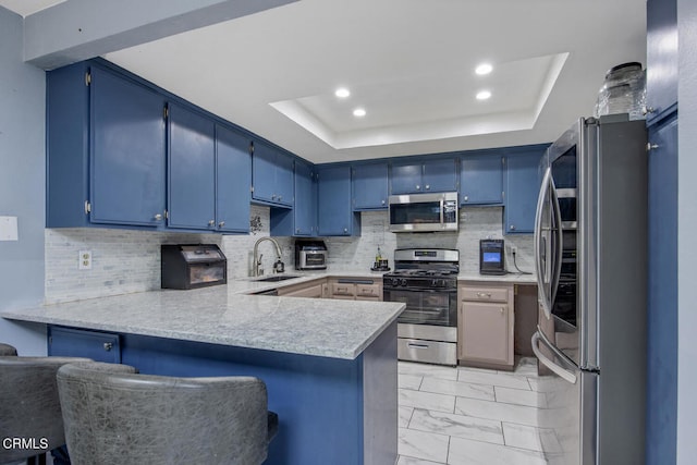 502 Holly Ave, Oxnard, CA 93036 - kitchen featuring appliances with stainless steel finishes, a peninsula, blue cabinets, a raised ceiling, and light countertops