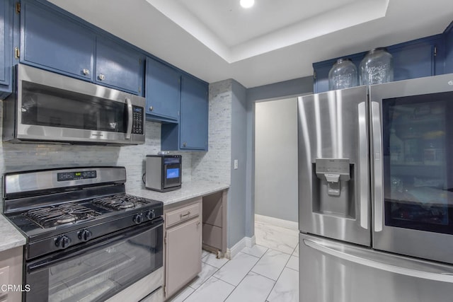 502 Holly Ave, Oxnard, CA 93036 - kitchen featuring stainless steel appliances, blue cabinetry, light marble finish floors, and tasteful backsplash
