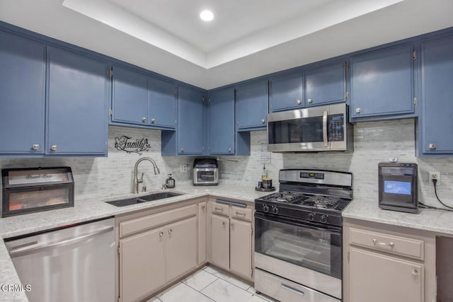 502 Holly Ave, Oxnard, CA 93036 - kitchen featuring stainless steel appliances, blue cabinetry, backsplash, and a tray ceiling