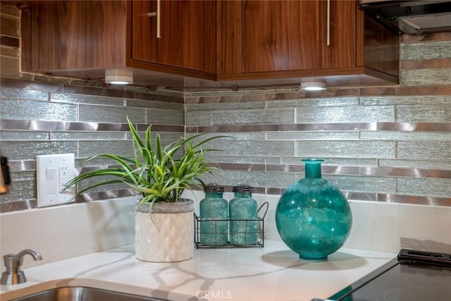 100 Scholz Plz Unit 205, Newport Beach, CA 92663 - kitchen view of backsplash, brown cabinets, light countertops, and exhaust hood