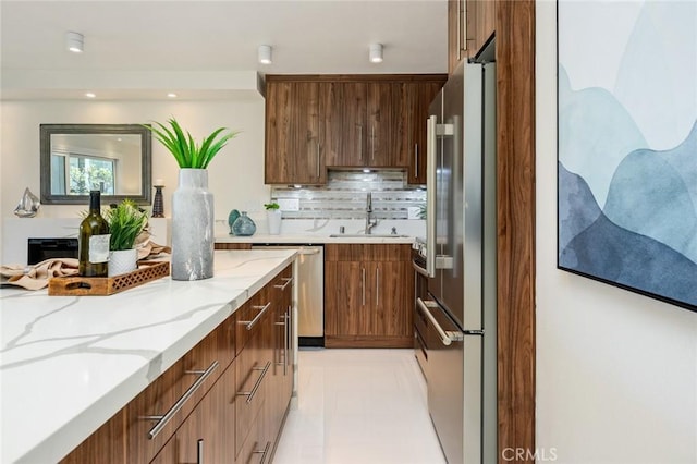 100 Scholz Plz Unit 205, Newport Beach, CA 92663 - kitchen featuring appliances with stainless steel finishes, modern cabinets, light stone countertops, decorative backsplash, and recessed lighting