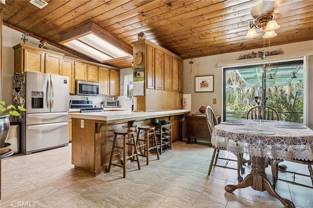 7050 Shale Rock Rd, Paso Robles, CA 93446 - kitchen featuring appliances with stainless steel finishes, wood ceiling, a peninsula, tasteful backsplash, and tile countertops