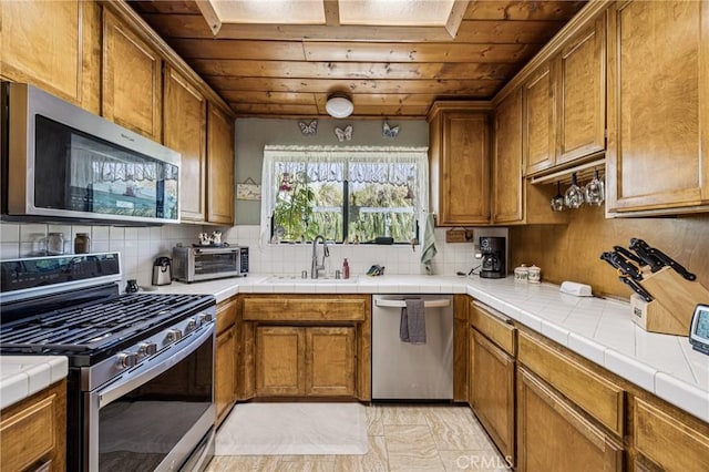 7050 Shale Rock Rd, Paso Robles, CA 93446 - kitchen featuring stainless steel appliances, wood ceiling, brown cabinets, backsplash, and tile countertops