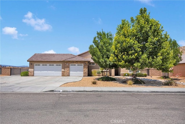 15558 Lookout Rd, Apple Valley, CA 92307 - view of front facade with driveway, a garage, stucco siding, stone siding, and a tile roof