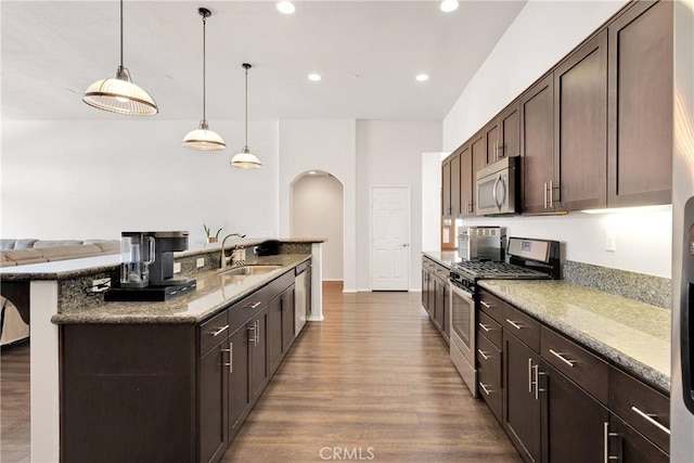15558 Lookout Rd, Apple Valley, CA 92307 - kitchen with stainless steel appliances, dark wood finished floors, arched walkways, dark brown cabinets, and recessed lighting