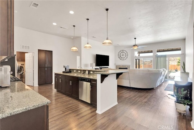 15558 Lookout Rd, Apple Valley, CA 92307 - kitchen with dishwasher, a fireplace, dark brown cabinetry, dark wood-style flooring, and recessed lighting