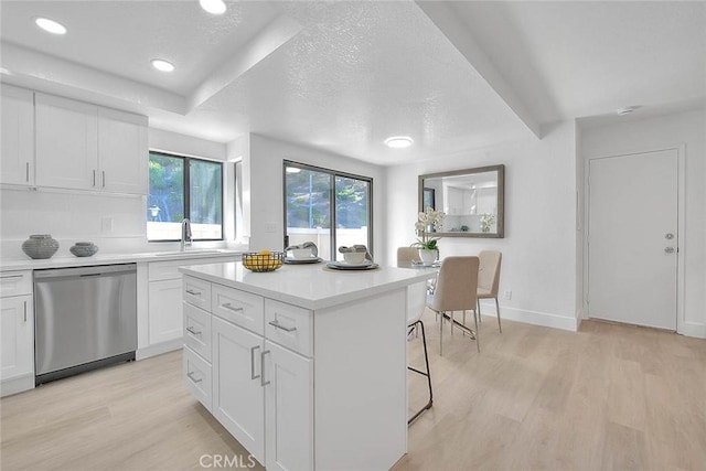 1207 Porto Grande Unit 1, Diamond Bar, CA 91765 - kitchen with stainless steel dishwasher, light wood-style flooring, light countertops, white cabinetry, and a textured ceiling