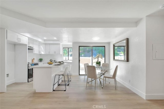 1207 Porto Grande Unit 1, Diamond Bar, CA 91765 - kitchen featuring electric stove, white cabinets, light wood-style floors, under cabinet range hood, and light countertops