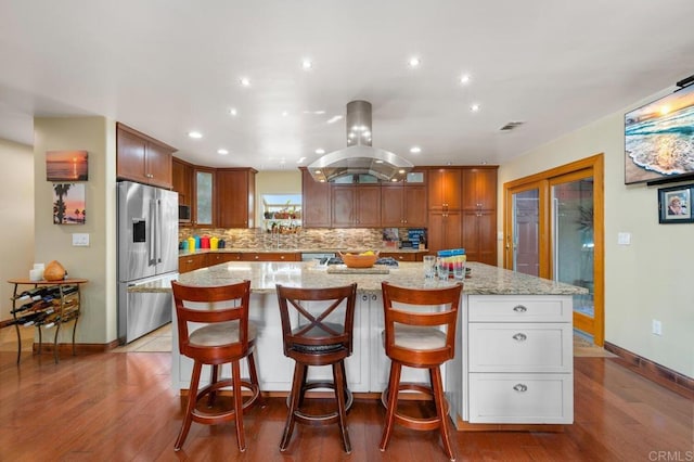 2722 Penkea Dr, Oceanside, CA 92054 - kitchen featuring stainless steel fridge with ice dispenser, island range hood, glass insert cabinets, tasteful backsplash, and wood finished floors