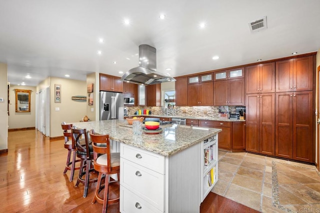 2722 Penkea Dr, Oceanside, CA 92054 - kitchen with island range hood, stainless steel appliances, a spacious island, decorative backsplash, and glass insert cabinets