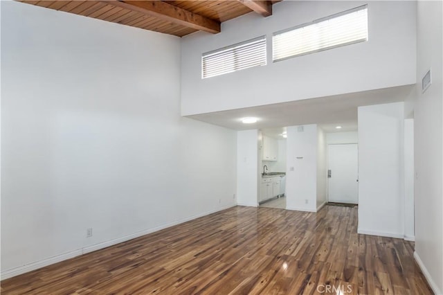 20134 Leadwell St Unit 337, Winnetka, CA 91306 - unfurnished living room featuring a towering ceiling, wood finished floors, and a wooden ceiling with exposed beams