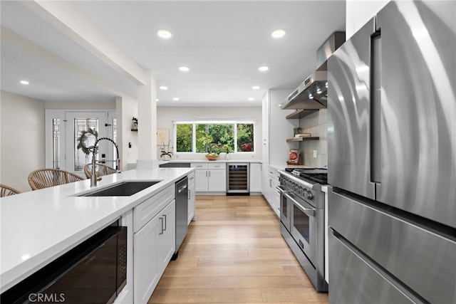 30361 Via Alcazar Ave, Laguna Niguel, CA 92677 - kitchen featuring appliances with stainless steel finishes, recessed lighting, light countertops, extractor fan, and light wood-type flooring