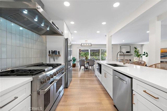 30361 Via Alcazar Ave, Laguna Niguel, CA 92677 - kitchen with stainless steel appliances, exhaust hood, light wood-type flooring, light countertops, and white cabinetry