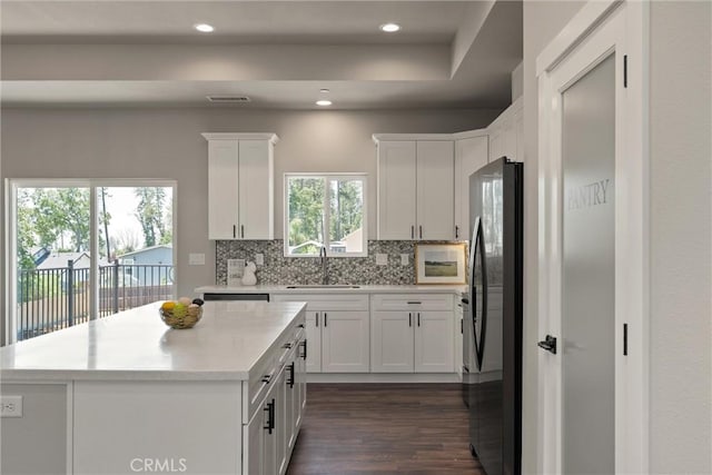 6169 Fern Ln, Paradise, CA 95969 - kitchen featuring freestanding refrigerator, dark wood finished floors, tasteful backsplash, light countertops, and white cabinets