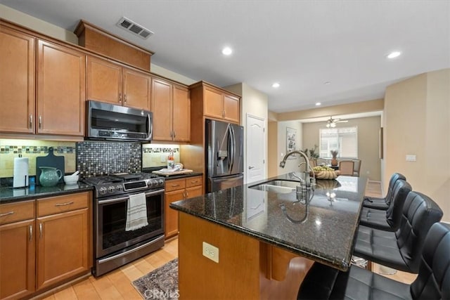 1061 Ford Dr, Nipomo, CA 93444 - kitchen featuring appliances with stainless steel finishes, light wood finished floors, backsplash, a kitchen bar, and recessed lighting