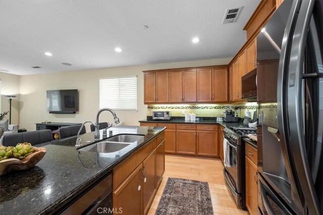 1061 Ford Dr, Nipomo, CA 93444 - kitchen featuring stainless steel appliances, dark stone countertops, open floor plan, recessed lighting, and brown cabinetry