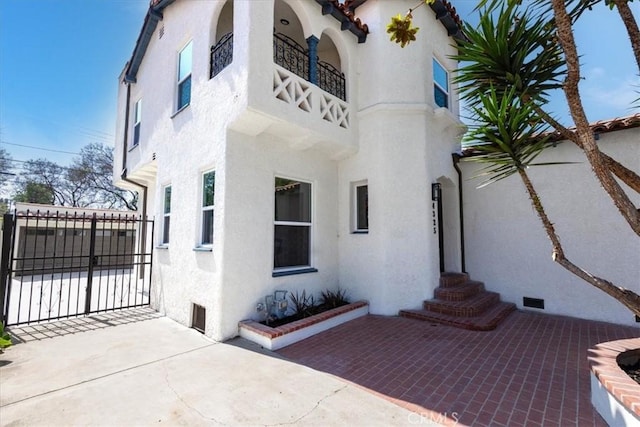 4325 9th Ave, Los Angeles, CA 90008 - back of house with a gate, stucco siding, and a balcony