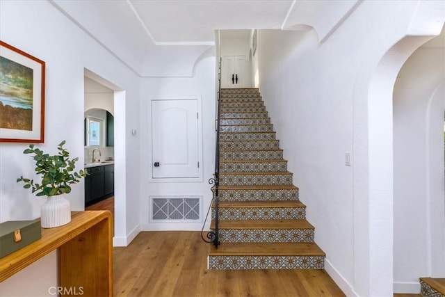4325 9th Ave, Los Angeles, CA 90008 - staircase with arched walkways and wood finished floors