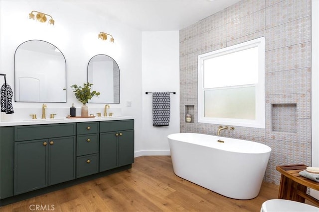 4325 9th Ave, Los Angeles, CA 90008 - bathroom featuring double vanity, a freestanding tub, wood finished floors, and a fireplace
