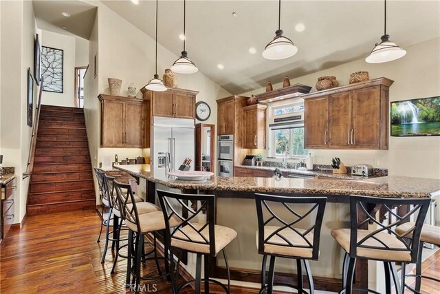 858 Fox Tower Way, Big Bear Lake, CA 92314 - kitchen with appliances with stainless steel finishes, dark wood-style floors, brown cabinets, a kitchen bar, and recessed lighting