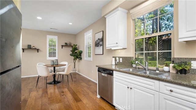 66 Full Moon, Irvine, CA 92618 - kitchen featuring appliances with stainless steel finishes, wood finished floors, white cabinetry, recessed lighting, and dark stone counters