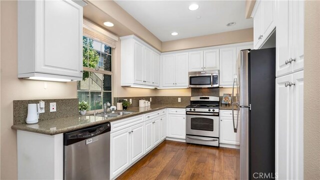 66 Full Moon, Irvine, CA 92618 - kitchen with stainless steel appliances, white cabinets, dark wood-style floors, tasteful backsplash, and recessed lighting