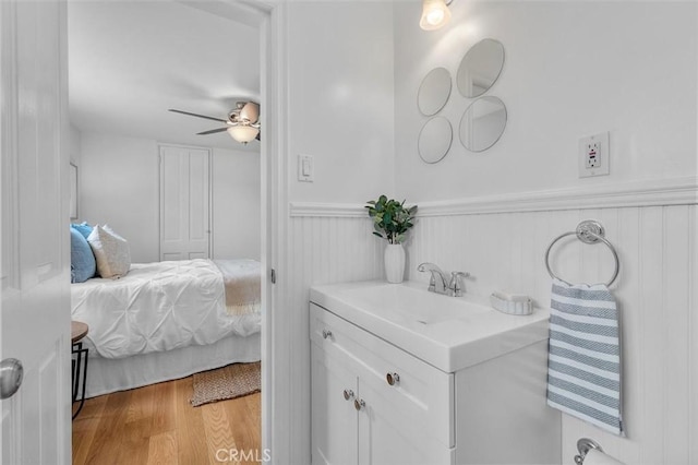 2322 246th St, Lomita, CA 90717 - bathroom with vanity, wainscoting, wood finished floors, a ceiling fan, and ensuite bath
