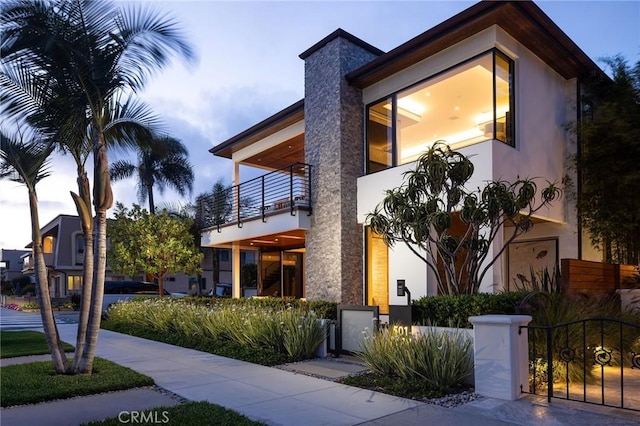 501 Ocean Ave, Seal Beach, CA 90740 - contemporary house featuring a balcony, a fenced front yard, stucco siding, and a gate