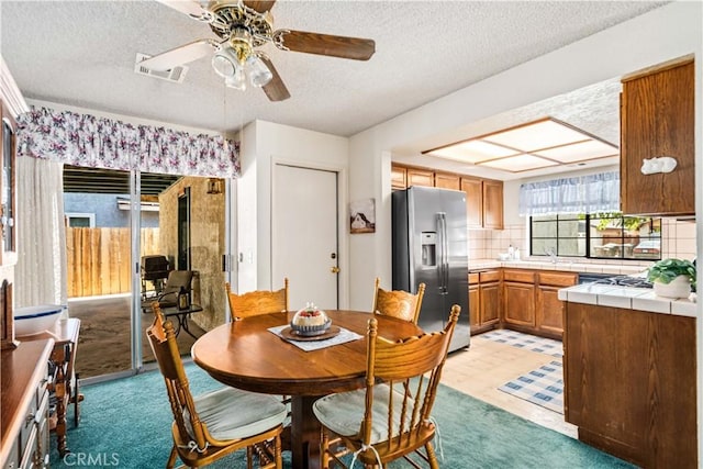 37229 Dalzell St, Palmdale, CA 93550 - dining space featuring a textured ceiling, a ceiling fan, light floors, and light colored carpet