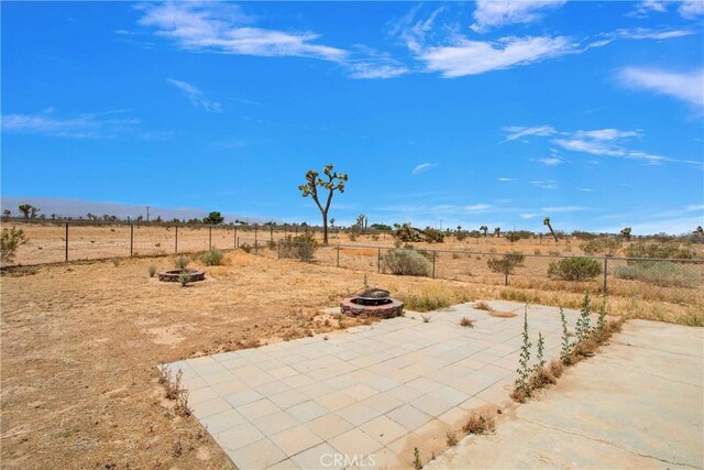 14480 Nevada Rd, Phelan, CA 92371 - fenced backyard featuring a fire pit, a patio, and a view of rural / pastoral area